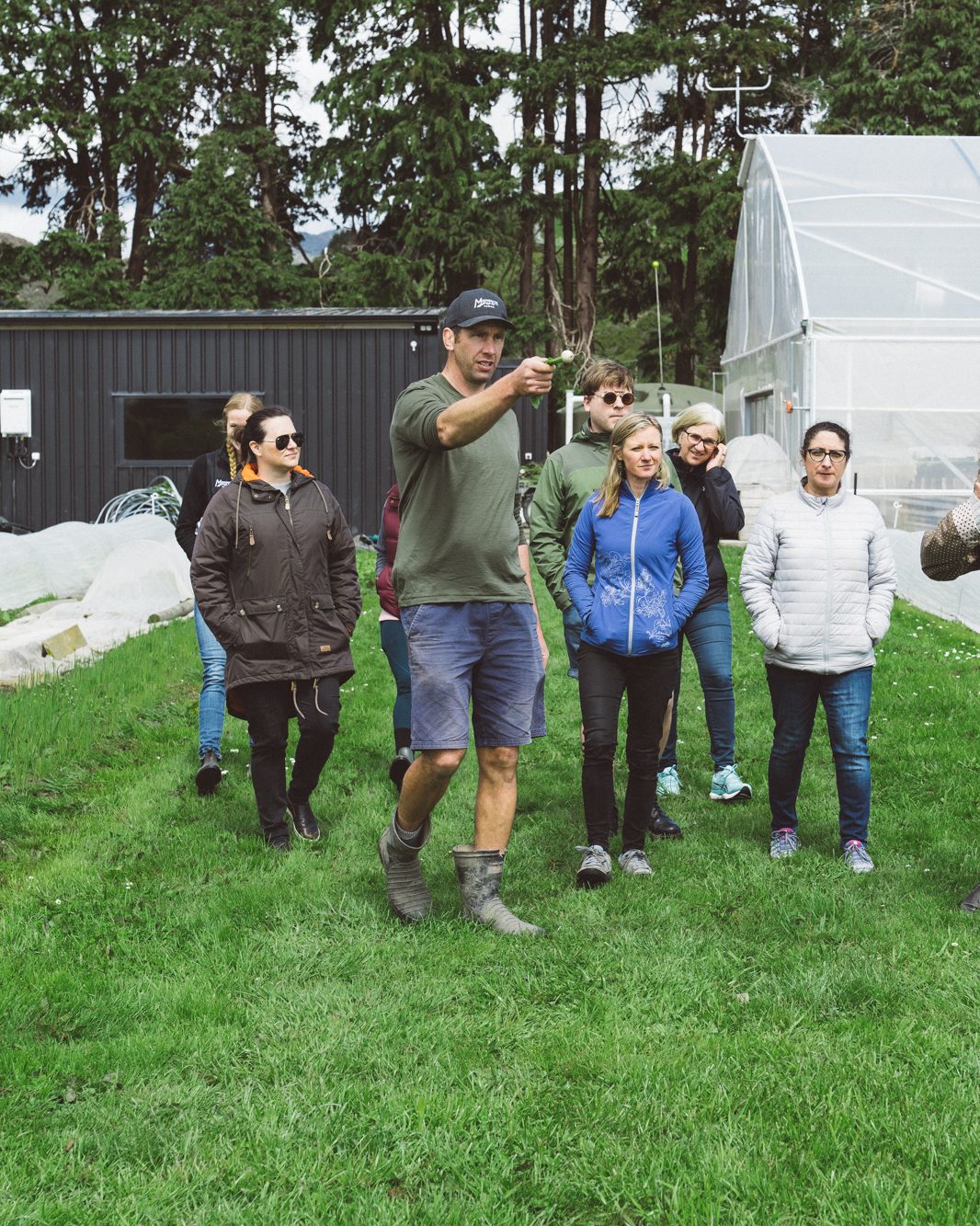 Cam leading a tour through the market garden, fresh-pulled onion in hand