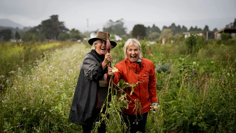 Two people in conversation among the flowers in the market garden