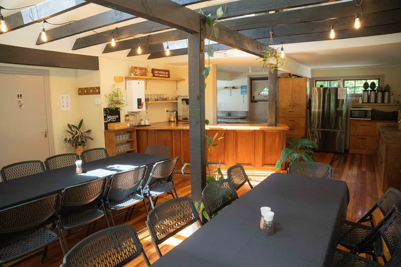 Long shared tables in Te Wharekai, warm timber and afternoon light
