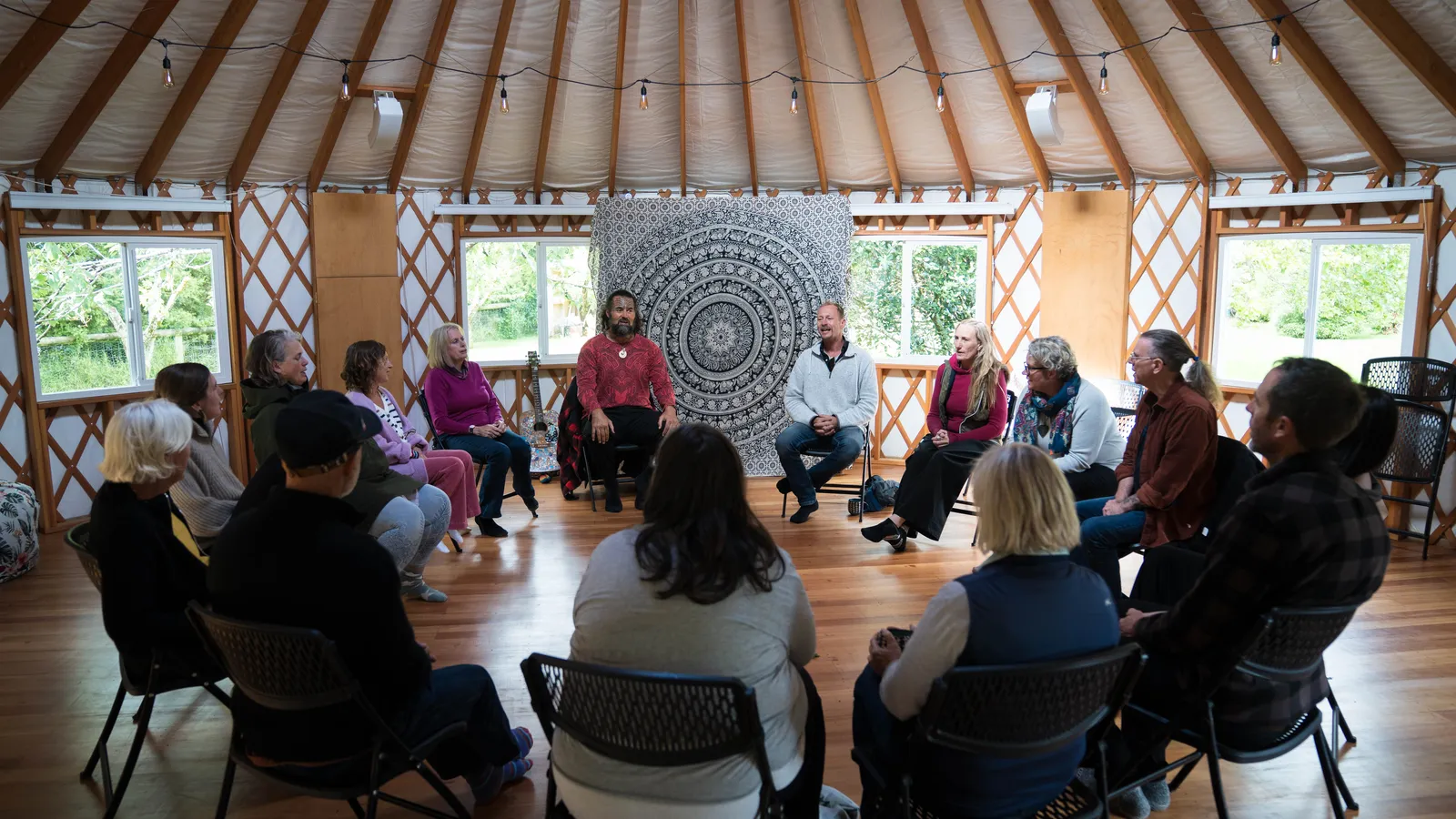 A circle of people in session inside the yurt at Mangaroa Farms